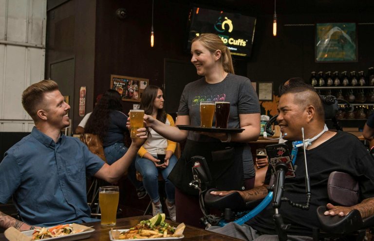 Polished concrete floor in a lively bar with patrons enjoying drinks and food, showcasing the stylish and durable finish of Perth's premium concrete polishing services.